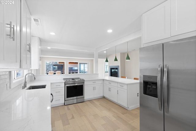 kitchen featuring sink, light wood-type flooring, appliances with stainless steel finishes, and a healthy amount of sunlight