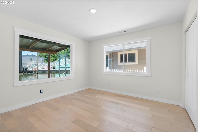 interior space with light hardwood / wood-style floors and a water view