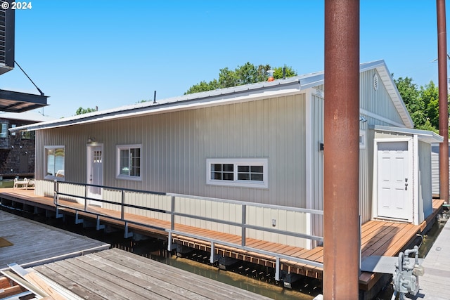 view of side of property with a water view and a dock