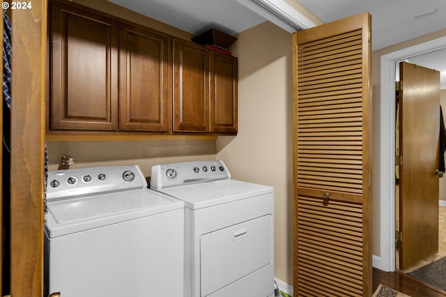 laundry room with cabinets, hardwood / wood-style floors, and washer and clothes dryer