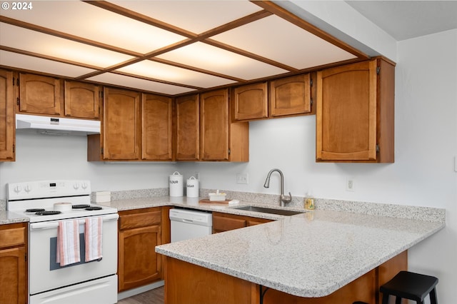 kitchen featuring kitchen peninsula, white appliances, sink, and light stone counters