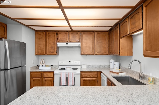 kitchen featuring white appliances, sink, and light stone counters