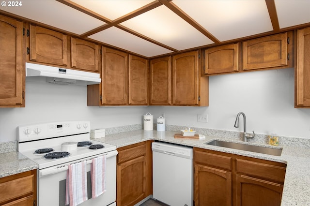 kitchen featuring light stone countertops, white appliances, and sink