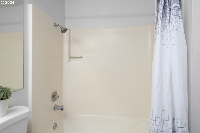 bathroom featuring shower / tub combo with curtain and toilet