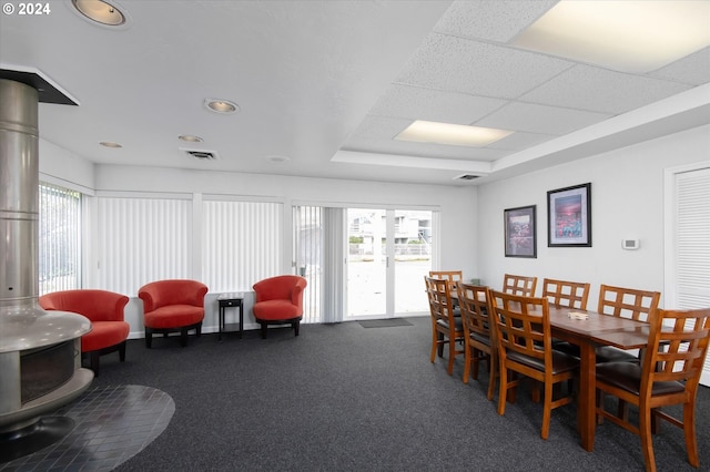 dining space with carpet floors and a drop ceiling