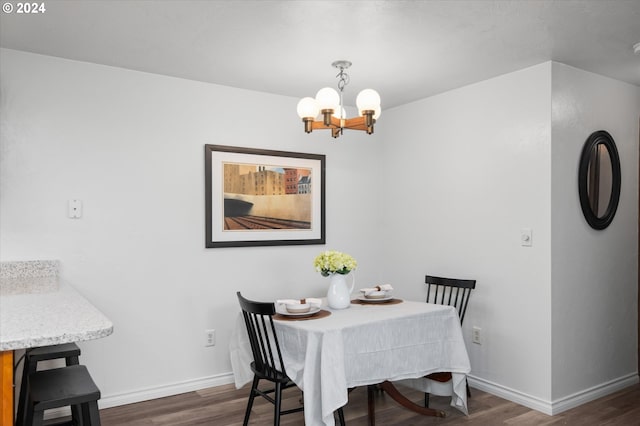 dining space with dark hardwood / wood-style flooring and an inviting chandelier