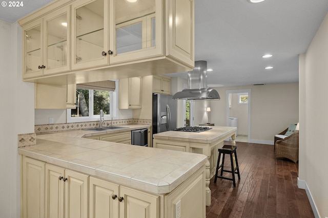 kitchen with kitchen peninsula, appliances with stainless steel finishes, sink, separate washer and dryer, and tile countertops