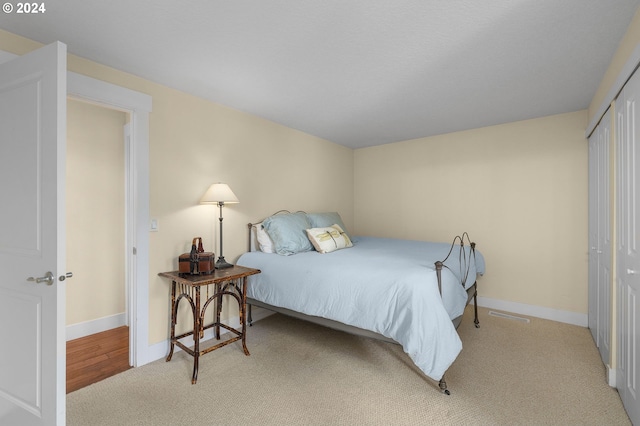 bedroom featuring a closet and light colored carpet