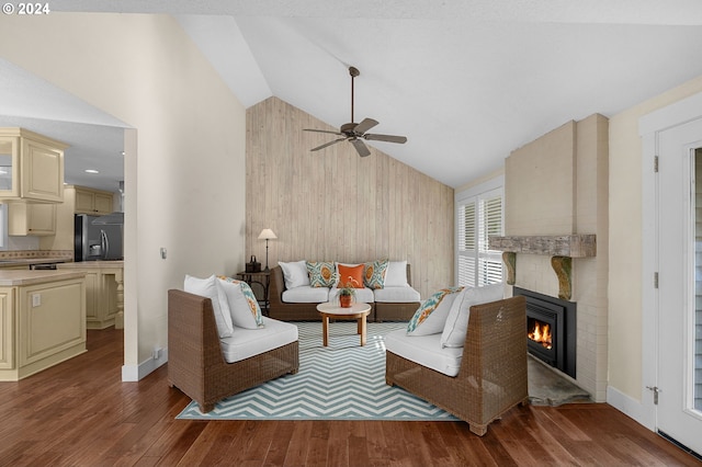 living room featuring a fireplace, dark hardwood / wood-style flooring, ceiling fan, wood walls, and lofted ceiling