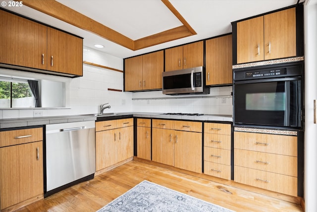 3320 NE 29th St, Gresham, OR 97030 - kitchen with appliances with stainless steel finishes, light wood-type flooring, decorative backsplash, a tray ceiling, and recessed lighting
