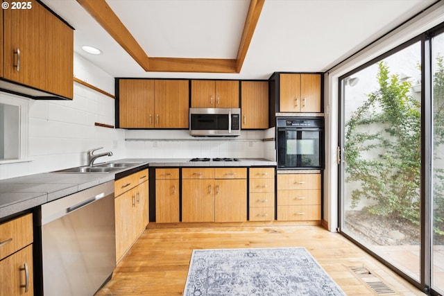 3320 NE 29th St, Gresham, OR 97030 - kitchen featuring appliances with stainless steel finishes, tasteful backsplash, a raised ceiling, and light wood finished floors