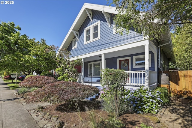 view of front of home featuring a porch and fence