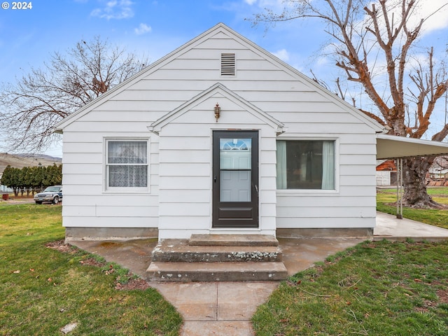 bungalow-style home featuring a front yard