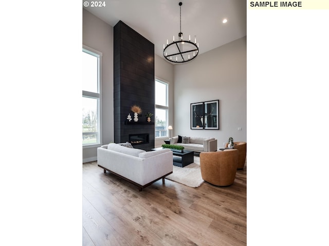 1108 N Helens View Dr, Ridgefield, WA 98642 - living room featuring a chandelier, light wood-style flooring, a high ceiling, a large fireplace, and recessed lighting