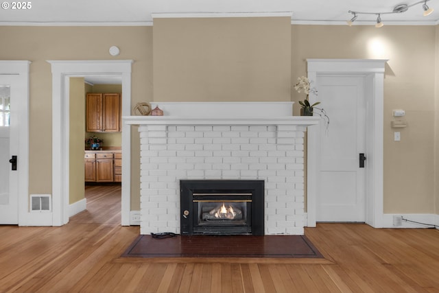 509 Kensington Ave, Astoria, OR 97103 - details with wood finished floors, visible vents, a fireplace, and ornamental molding