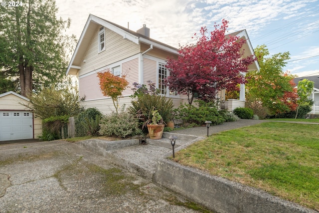 view of side of home with an outbuilding, a yard, and a garage