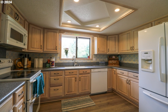 kitchen featuring sink, dark wood-type flooring, a textured ceiling, white appliances, and a tray ceiling