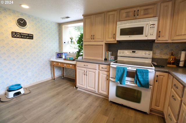 kitchen featuring a textured ceiling, white appliances, and light hardwood / wood-style flooring