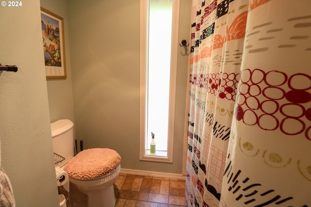 bathroom with a shower with shower curtain and toilet