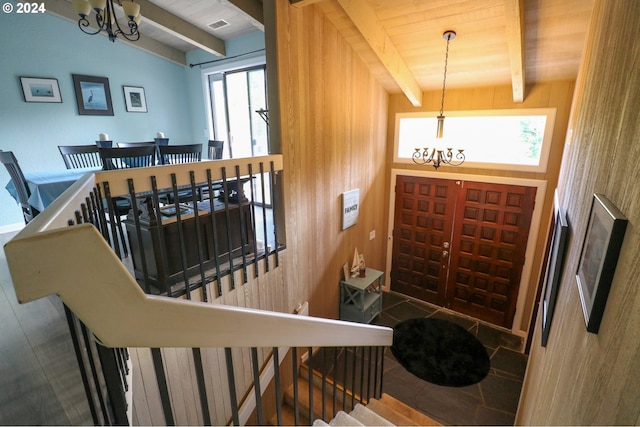 entrance foyer with wood ceiling, vaulted ceiling with beams, a healthy amount of sunlight, and a notable chandelier