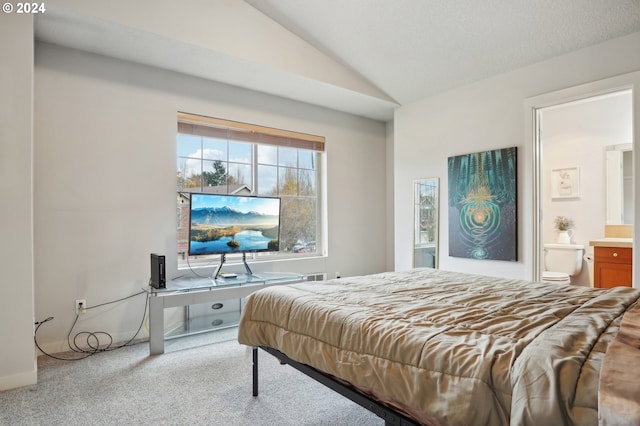 bedroom with a textured ceiling, ensuite bath, light colored carpet, and lofted ceiling