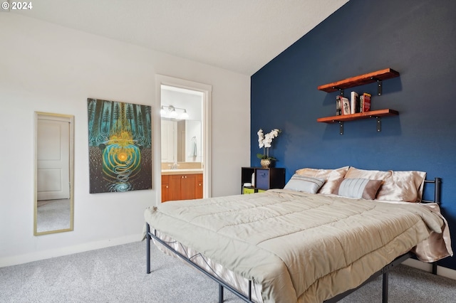 bedroom featuring ensuite bathroom, sink, carpet, and lofted ceiling