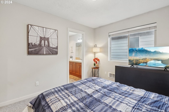 bedroom featuring light carpet, a textured ceiling, connected bathroom, and sink