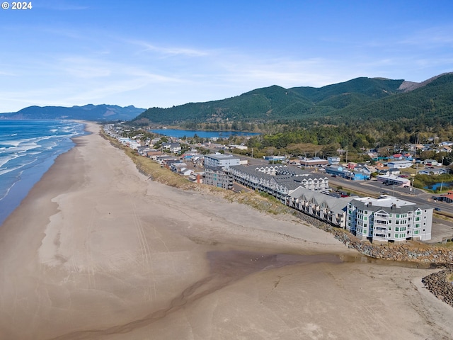 birds eye view of property with a water and mountain view and a beach view