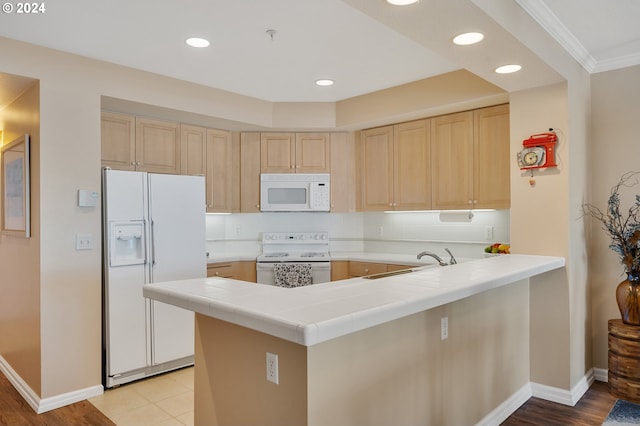 kitchen with kitchen peninsula, light wood-type flooring, white appliances, sink, and tile countertops