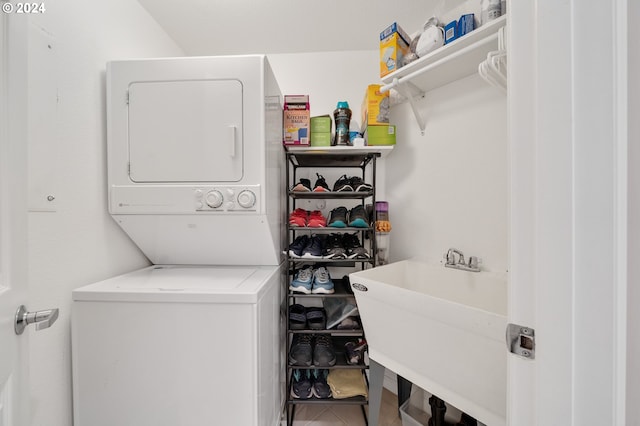 laundry area featuring stacked washer and clothes dryer and sink