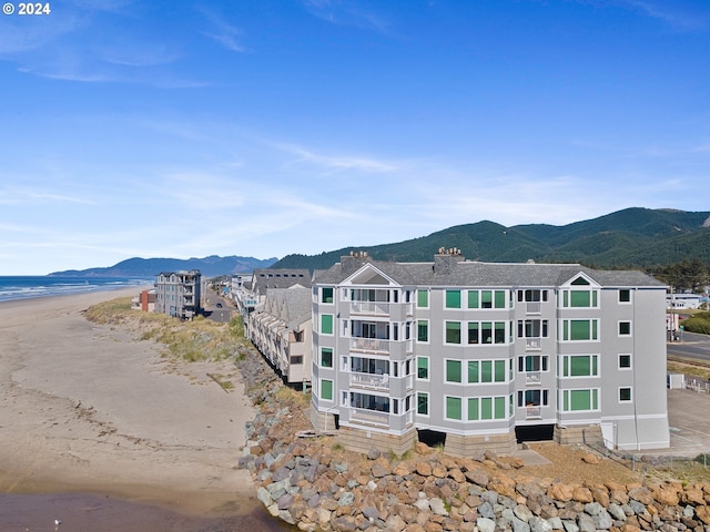 aerial view featuring a view of the beach and a water and mountain view