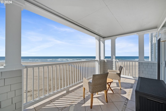 balcony featuring a beach view and a water view