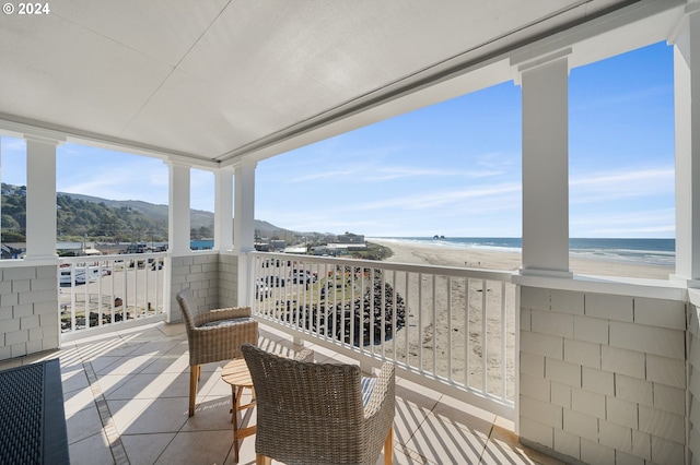 balcony featuring a water view and a beach view