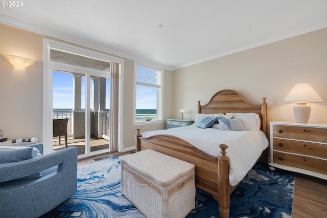 bedroom featuring hardwood / wood-style floors, a water view, ornamental molding, and access to outside