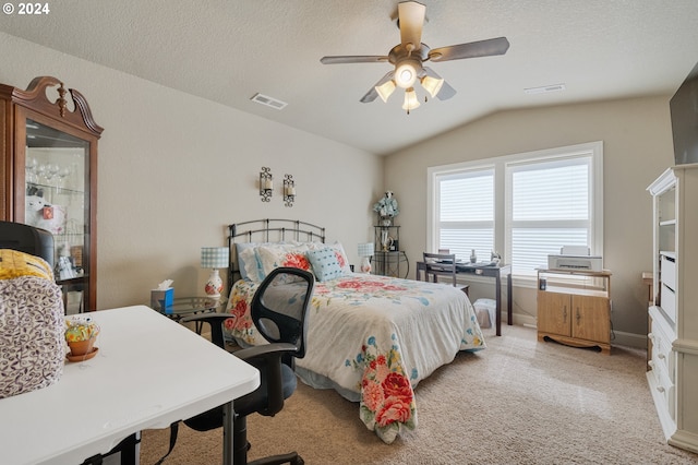 bedroom with ceiling fan, light colored carpet, lofted ceiling, and a textured ceiling