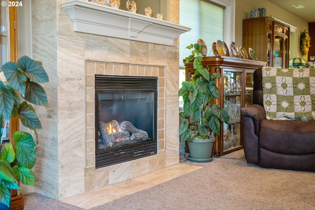 room details featuring a tiled fireplace and carpet flooring