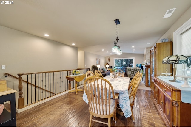 dining space featuring hardwood / wood-style flooring and vaulted ceiling