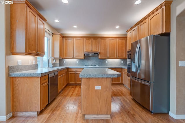 kitchen featuring sink, a kitchen island, light hardwood / wood-style floors, and appliances with stainless steel finishes