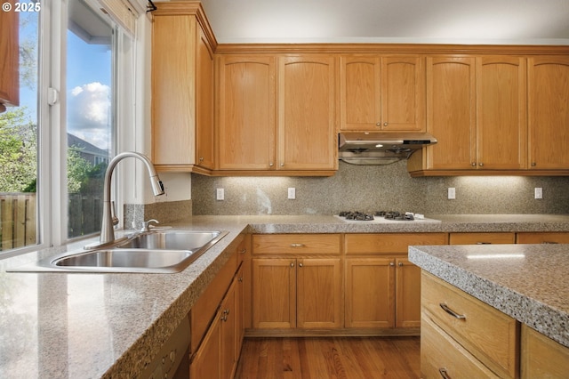 5306 NW Skycrest Pkwy, Portland, OR 97229 - kitchen with under cabinet range hood, backsplash, a sink, white gas stovetop, and light wood-type flooring