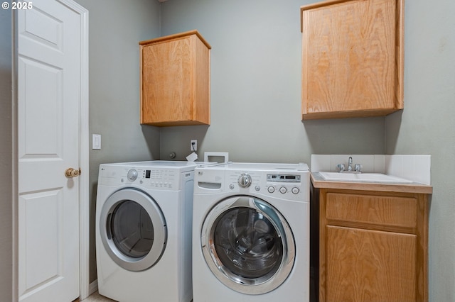 laundry room with cabinets, separate washer and dryer, and sink