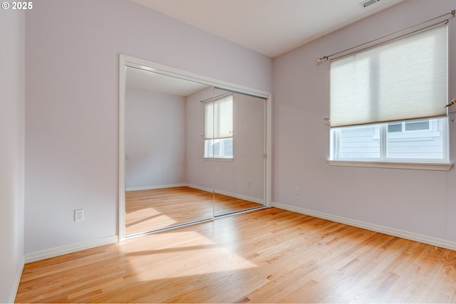 unfurnished bedroom featuring light hardwood / wood-style floors and a closet