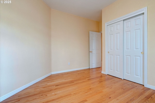 unfurnished bedroom with a closet and light hardwood / wood-style flooring