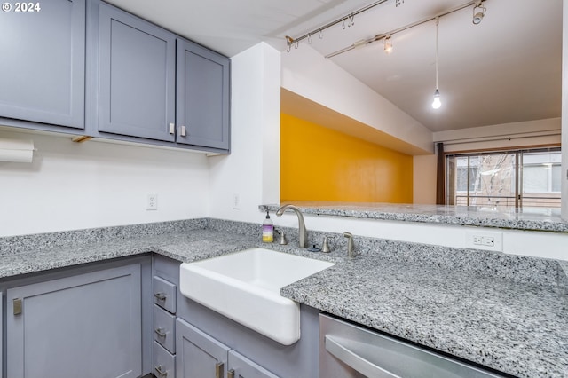 kitchen featuring gray cabinetry, sink, rail lighting, light stone counters, and dishwasher