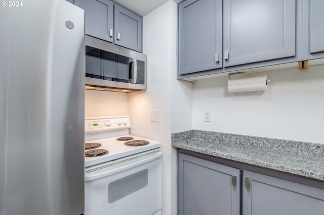 kitchen featuring refrigerator, white range with electric stovetop, light stone counters, and gray cabinets