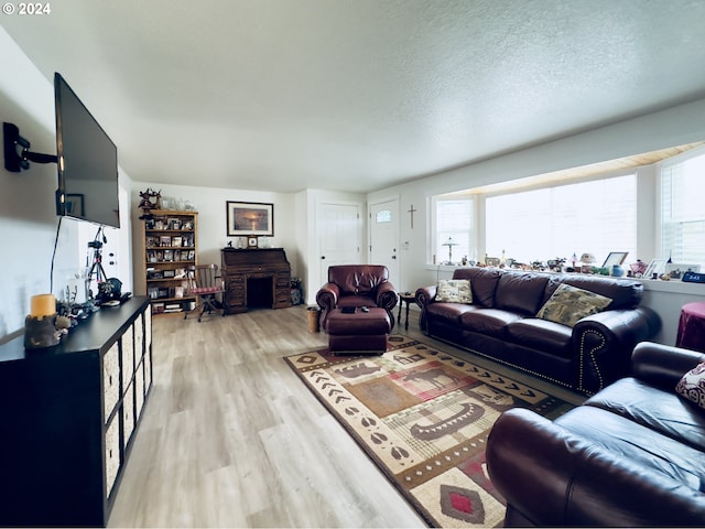 living room featuring a textured ceiling and light hardwood / wood-style flooring