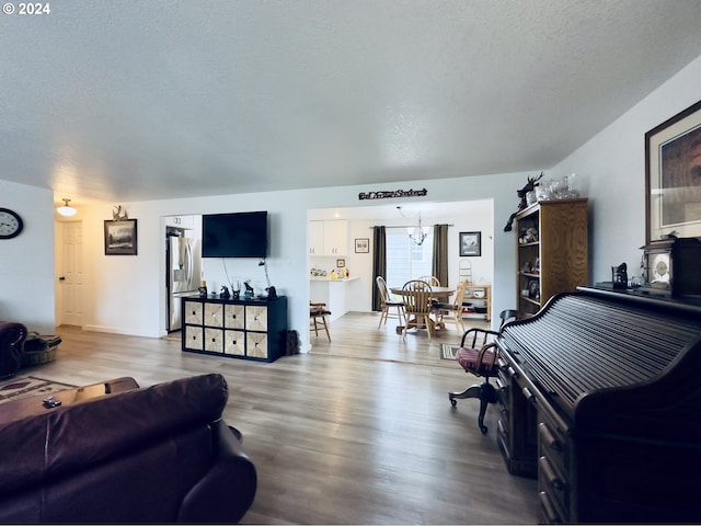 living room featuring light wood-type flooring and a textured ceiling