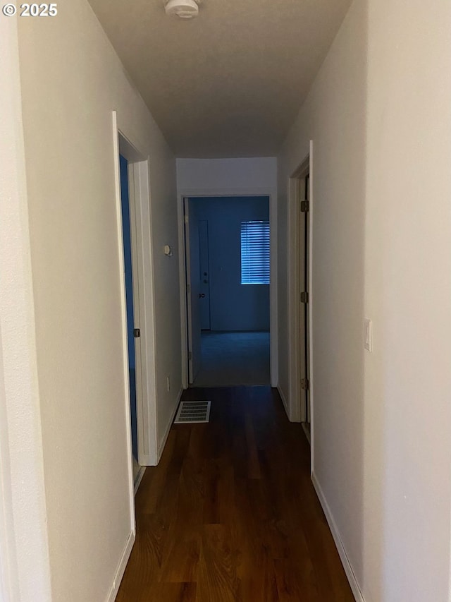 corridor with dark hardwood / wood-style floors