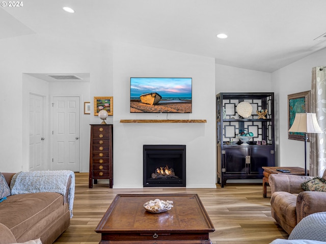 living room featuring vaulted ceiling and light hardwood / wood-style flooring