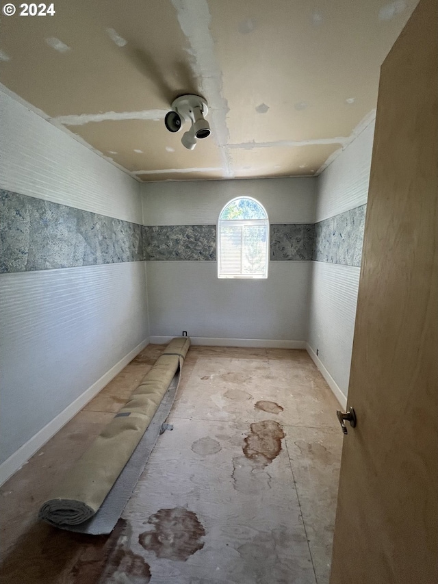 unfurnished room with wainscoting