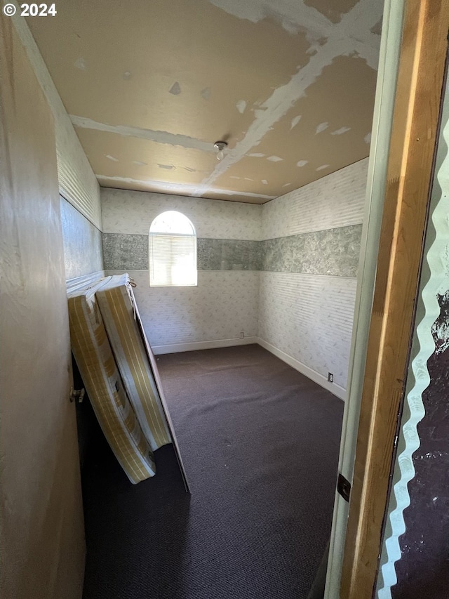 interior space featuring baseboards, carpet floors, and wallpapered walls